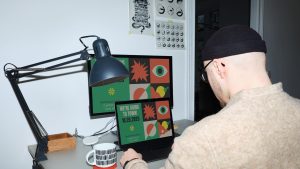 Seorang desainer grafis mengoperasikan software dalam laptop